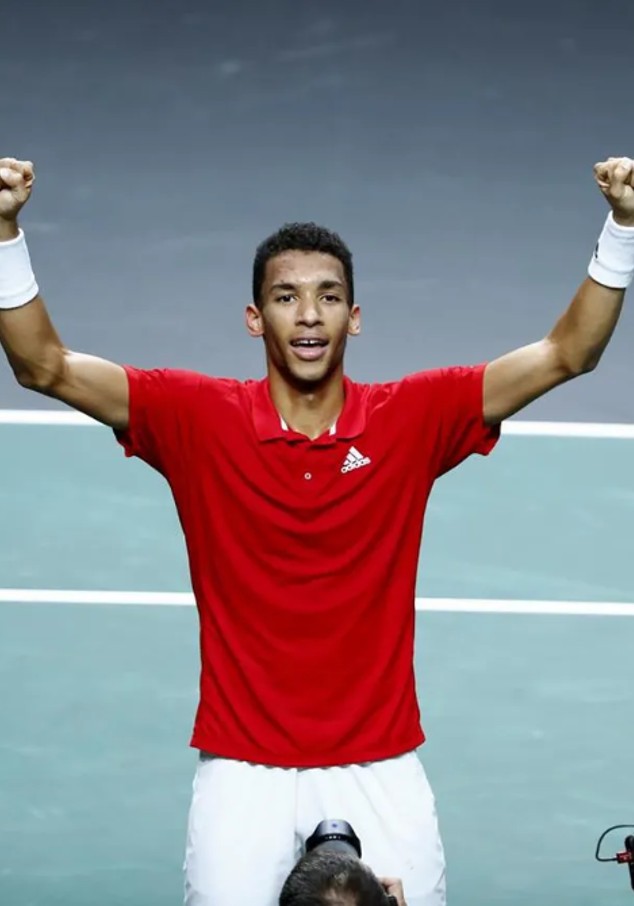 Sports player with raised hands in front of cameramen